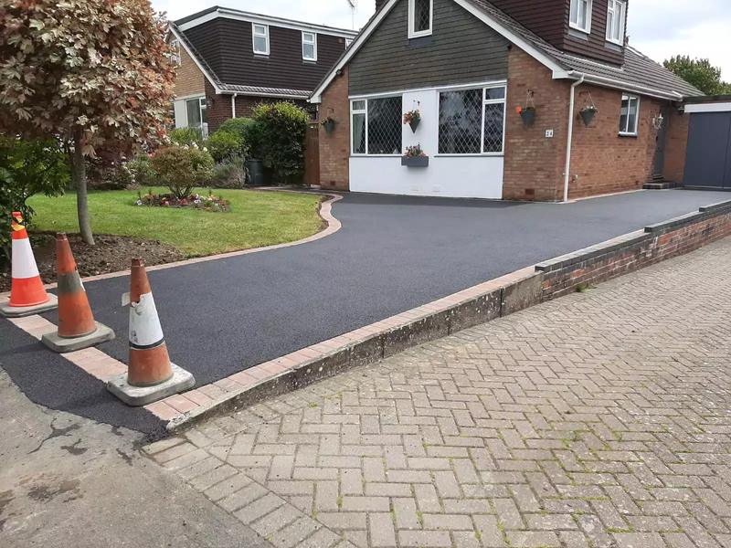 Freshly laid tarmac driveway with block paving apron